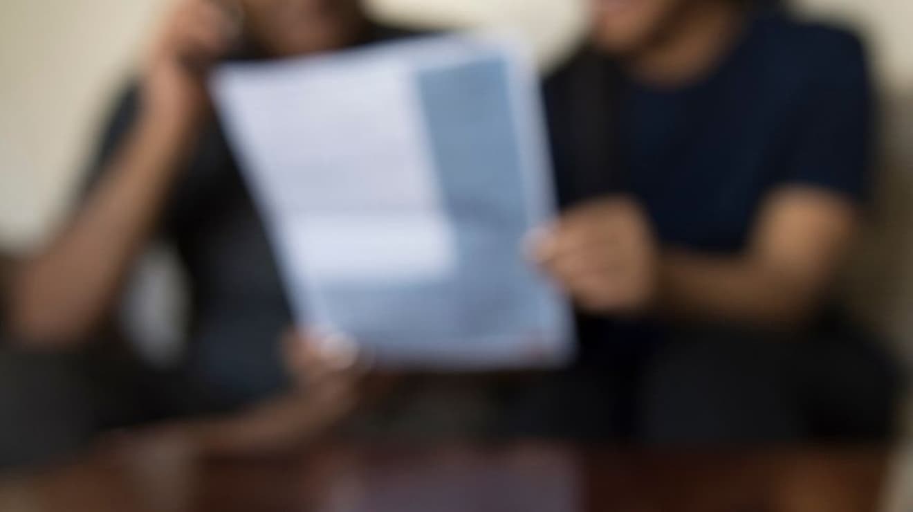 Blurred image showing a couple holding a water bill