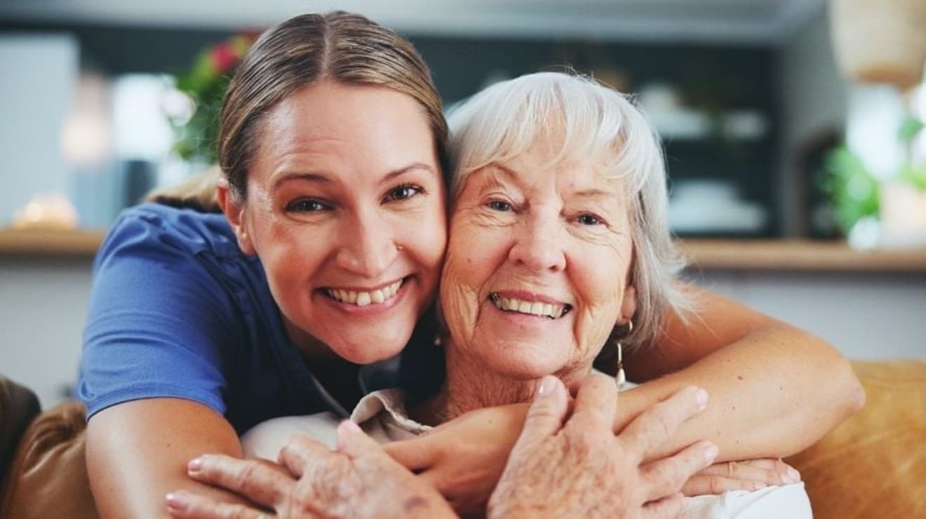 elderly lady sat on the sofa with carer