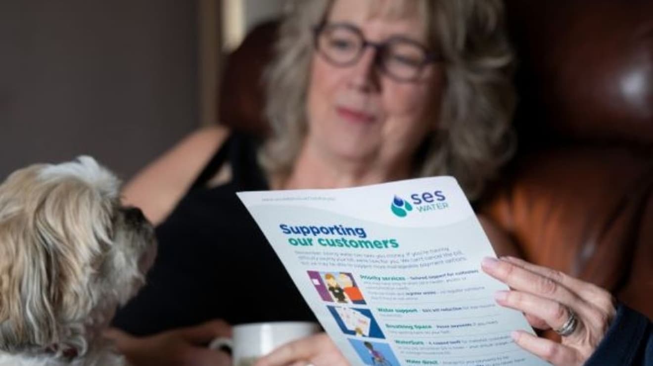 Woman reading SES Water bill